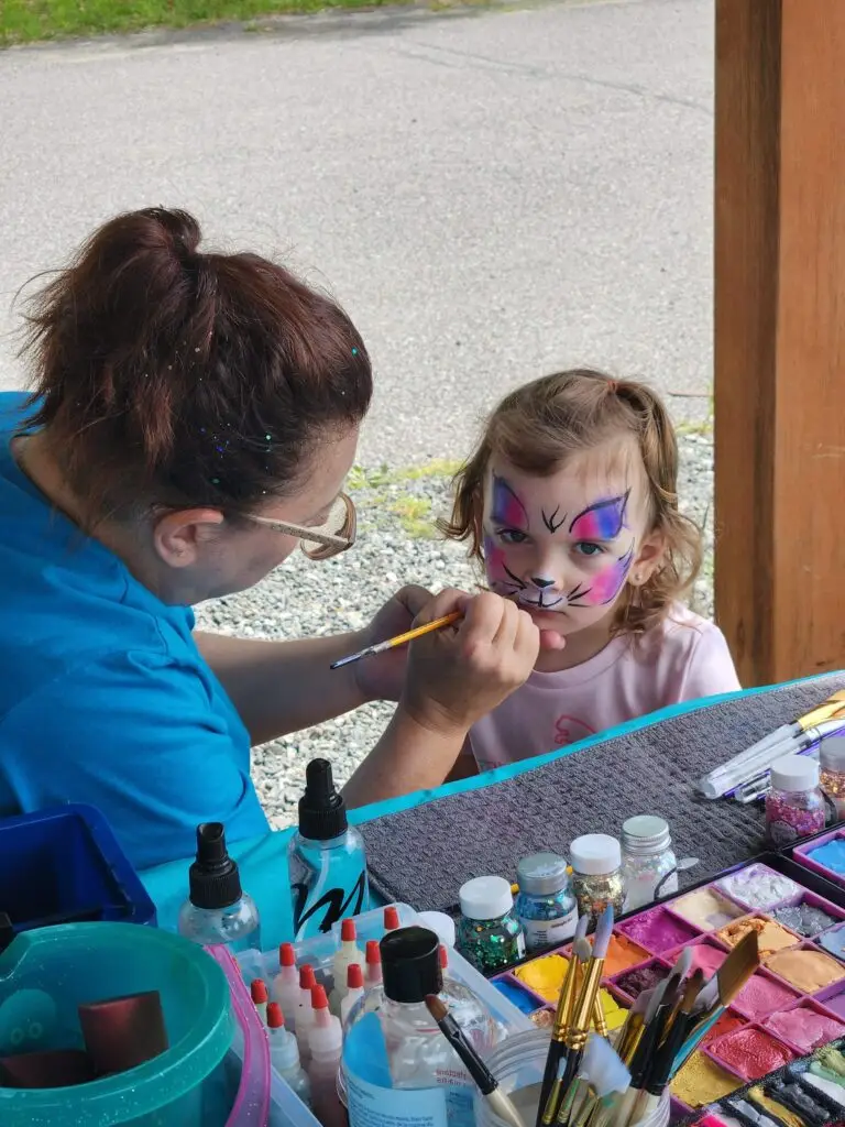 a woman painting a child's face